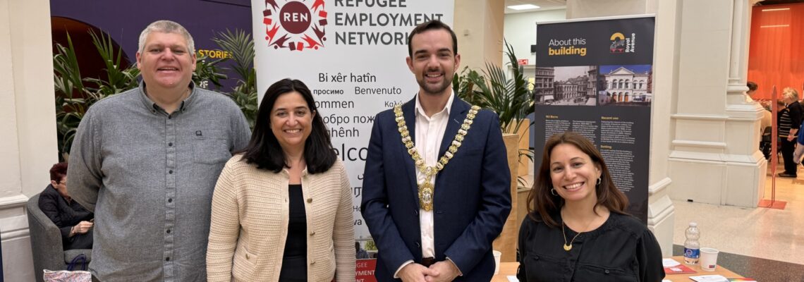 Four people standing in front of the Refugee Employment Network banner. One of them is the Lord Mayor, with a Mayor necklace on.