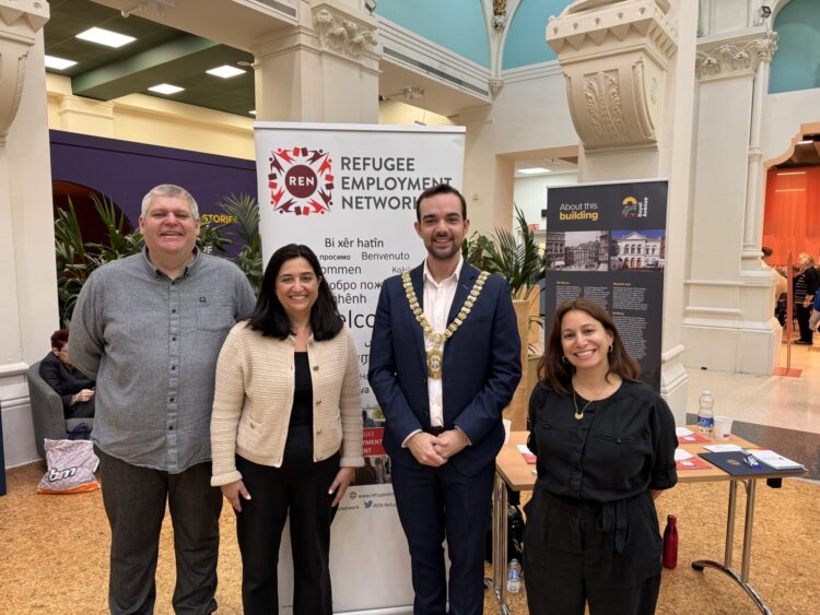 Four people standing in front of the Refugee Employment Network banner. One of them is the Lord Mayor, with a Mayor necklace on. 