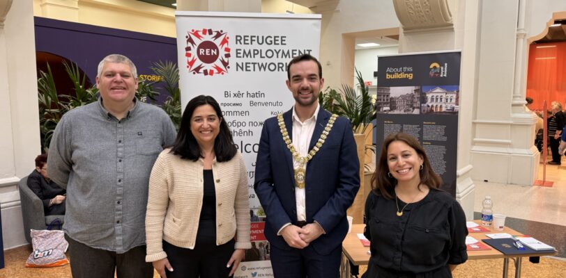 Four people standing in front of the Refugee Employment Network banner. One of them is the Lord Mayor, with a Mayor necklace on.